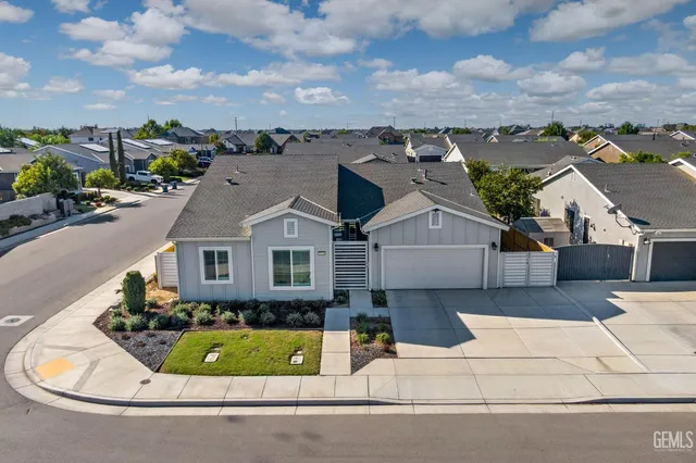 an aerial view of a house with a garden and lake view