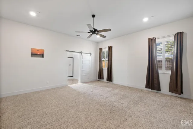 a view of an empty room with a ceiling fan