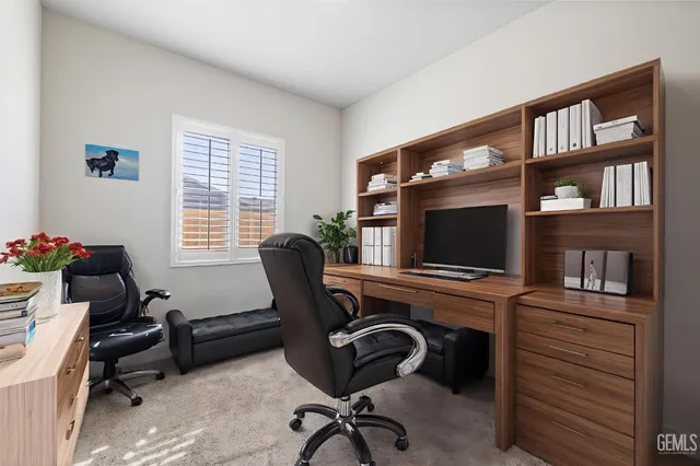a view of a workspace with a window and a flat screen tv