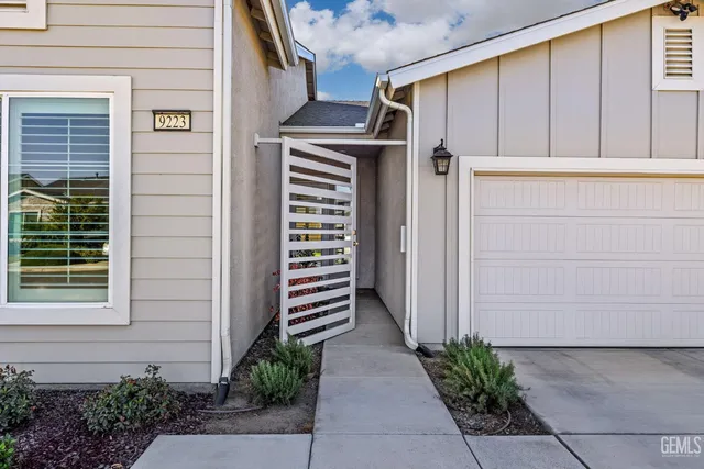a front view of a house with garage and plants