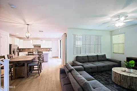 a living room with furniture ceiling fan and a window
