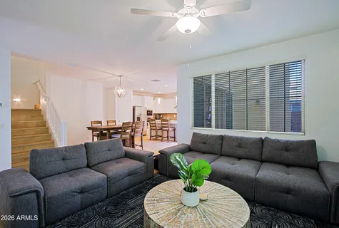 a living room with furniture a flat screen tv and kitchen view