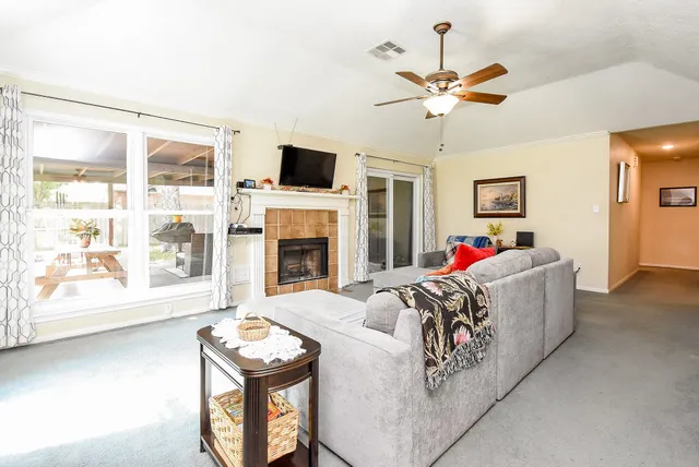a living room with furniture kitchen view and a chandelier