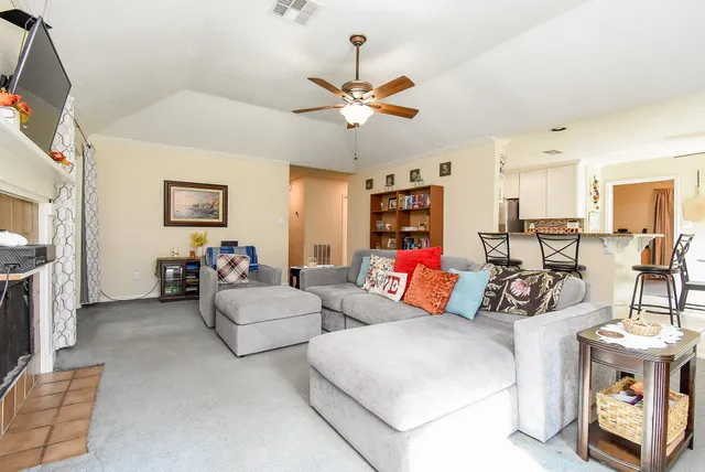 a living room with furniture a bookshelf and a window