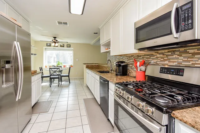a kitchen with stainless steel appliances granite countertop a sink stove and refrigerator