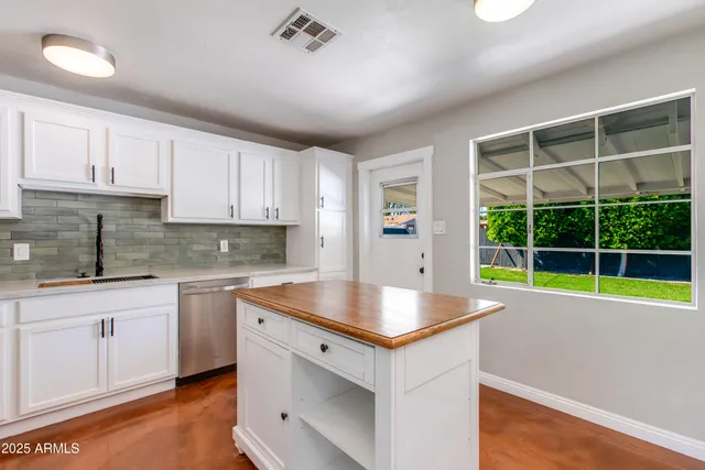 a kitchen with a sink window and cabinets