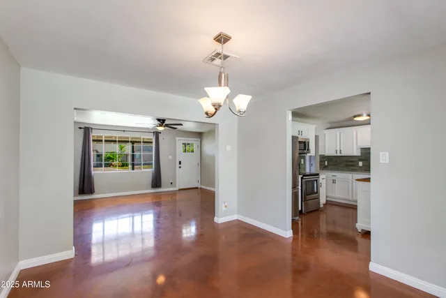 a view of a hallway with wooden floor a chandelier and living room