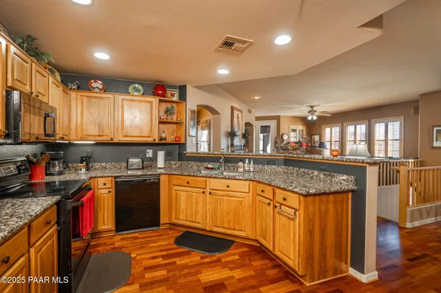 a kitchen with stainless steel appliances granite countertop a stove sink and cabinets