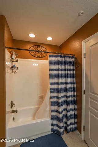 a living room with lots of furniture and a fan