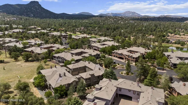 a view of a sign board with flower plants in front of main door