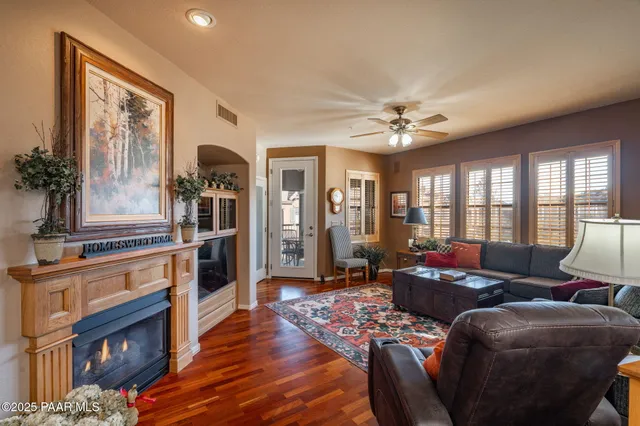 a living room with furniture a fireplace and a chandelier