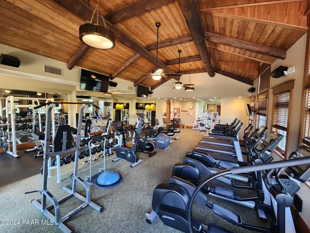 a view of a patio with table and chairs under an umbrella with a barbeque