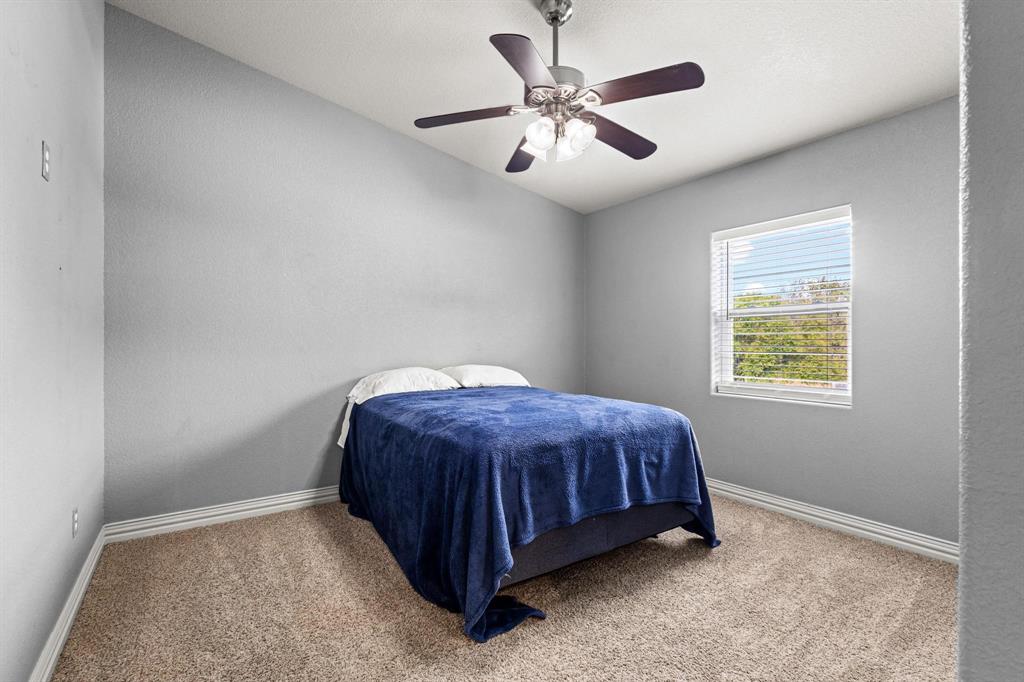 595 Pleasant Home Road Sherman, TX 75092 - Photo 19 of 40 a spacious bedroom with a bed and a chandelier