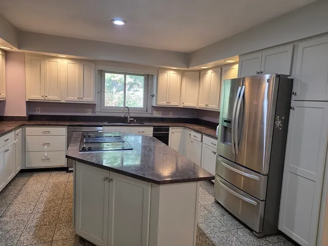 a kitchen with stainless steel appliances granite countertop a refrigerator a sink a stove and island