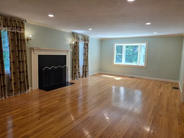 a view of an empty room with a fireplace and a window