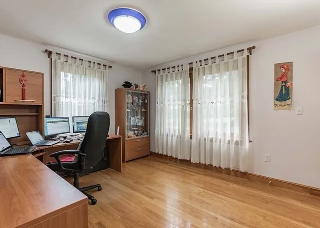 a view of a workspace with furniture and a window