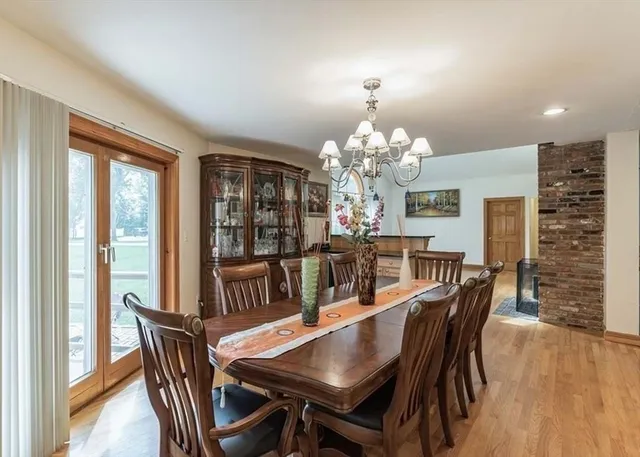 a dining room with furniture a chandelier and wooden floor