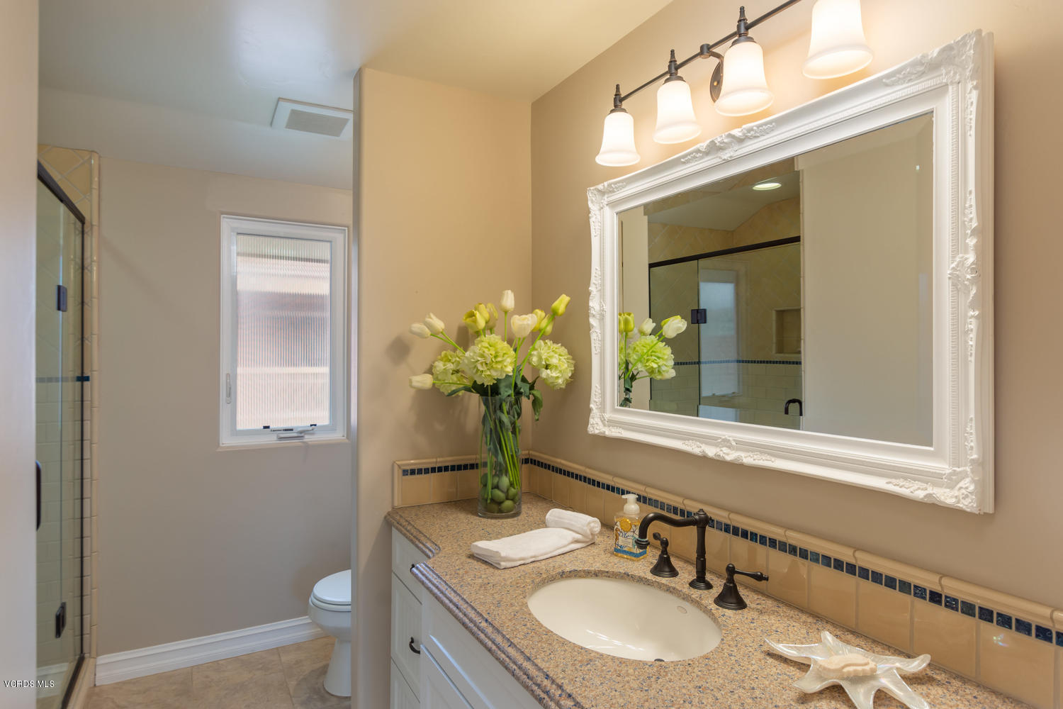 2301 Peninsula Road Oxnard, CA 93035 - Photo 23 of 37 a bathroom with a granite countertop sink toilet and mirror