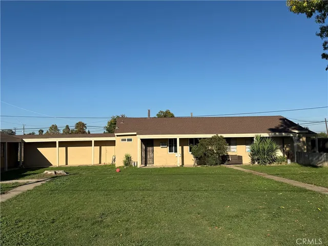 a front view of a house with a yard and lake