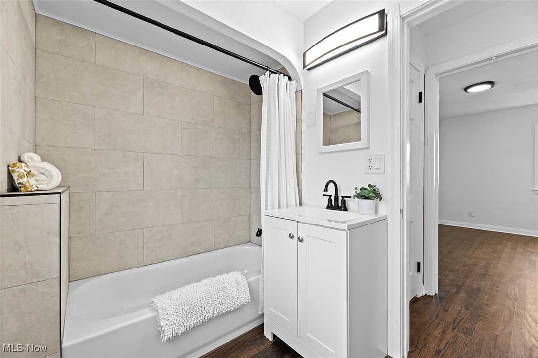 7719 Ackley Road Parma, OH 44129 - Photo 29 of 35 Bathroom featuring shower / tub combo with curtain, wood finished floors, and vanity