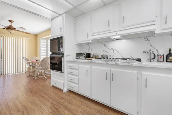 a kitchen with white cabinets and sink