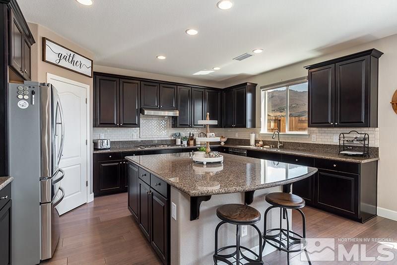 2785 Tobiano Drive Reno, NV 89521 - Photo 9 of 27 a kitchen with granite countertop a sink stove and refrigerator