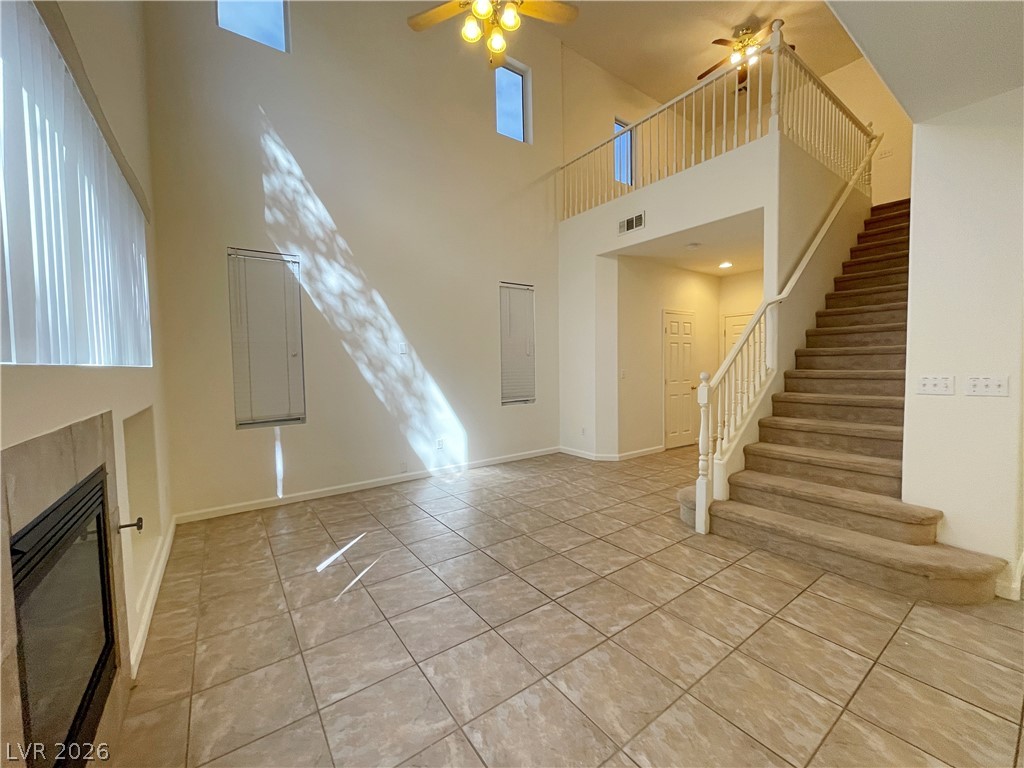 691 Principle Point Avenue Henderson, NV 89012 - Photo 5 of 30 A spacious living area with soaring ceilings and a cozy fireplace creates an inviting atmosphere.