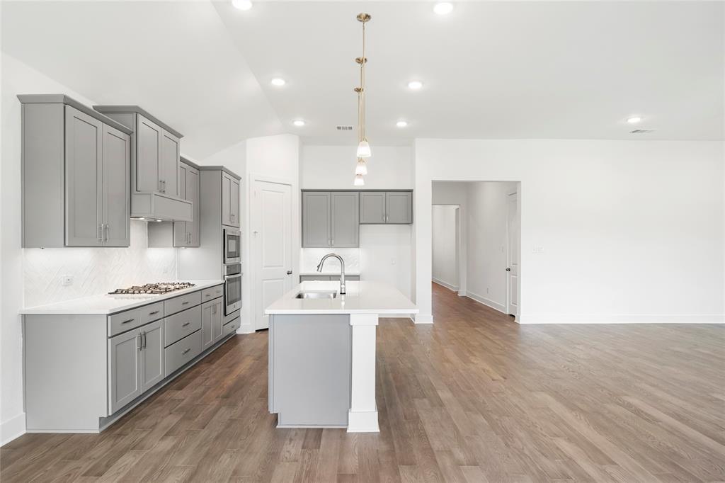 2900 Barbary Road McKinney, TX 75071 - Photo 12 of 36 Contemporary kitchen with gray cabinetry, white countertops, stainless steel appliances, and wood-finish flooring
