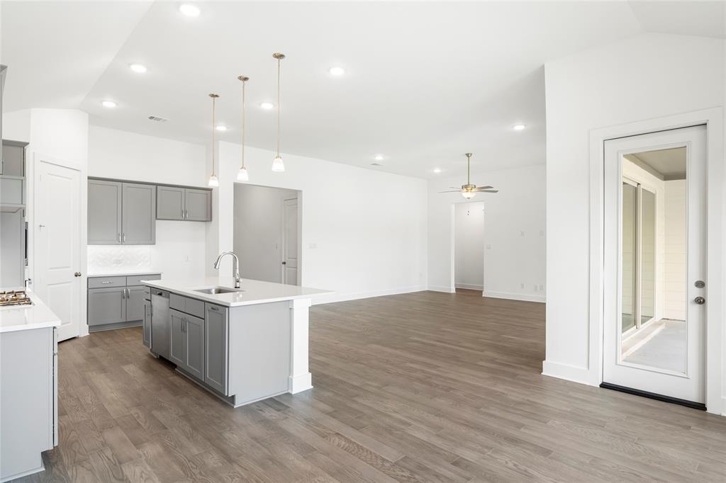 2900 Barbary Road McKinney, TX 75071 - Photo 16 of 36 Open-concept living space featuring wood-finish flooring, recessed lighting, and a kitchen island with pendant lighting