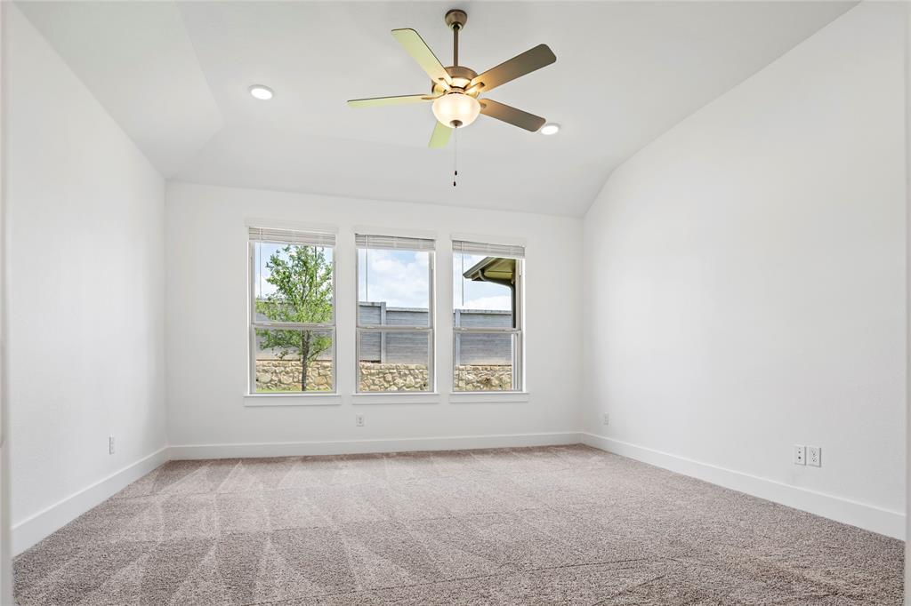 2900 Barbary Road McKinney, TX 75071 - Photo 23 of 36 Spacious interior room featuring a vaulted ceiling with a ceiling fan, recessed lighting, three large windows, and patterned carpet flooring