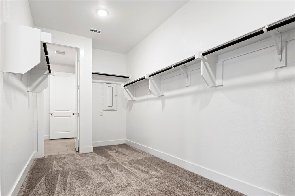 2900 Barbary Road McKinney, TX 75071 - Photo 26 of 36 Spacious walk-in closet featuring light gray carpet flooring, white walls, built-in shelving, and clothing rods