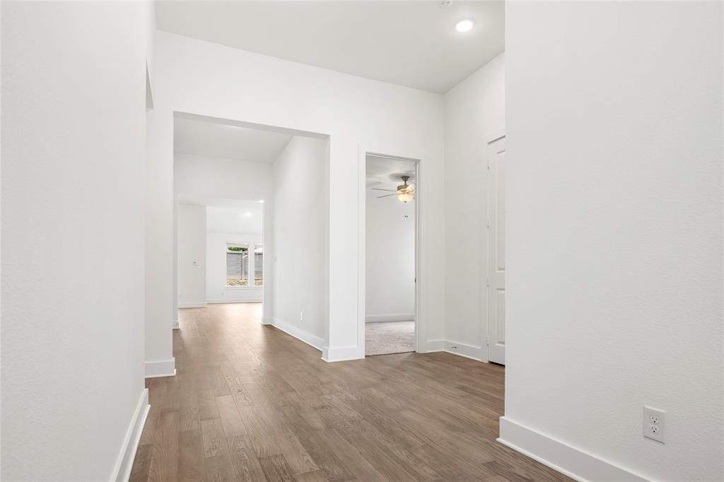 2900 Barbary Road McKinney, TX 75071 - Photo 3 of 36 Hallway with wood-finish flooring, white baseboards, and bright white walls