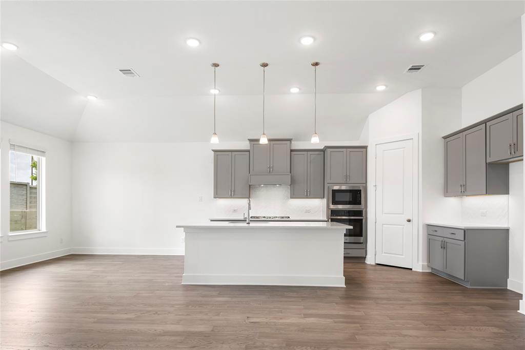 2900 Barbary Road McKinney, TX 75071 - Photo 5 of 36 Open-concept kitchen and living area featuring wood-finish flooring, recessed lighting, and a vaulted ceiling