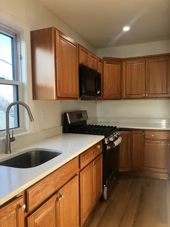 a kitchen with stainless steel appliances granite countertop a sink stove and cabinets
