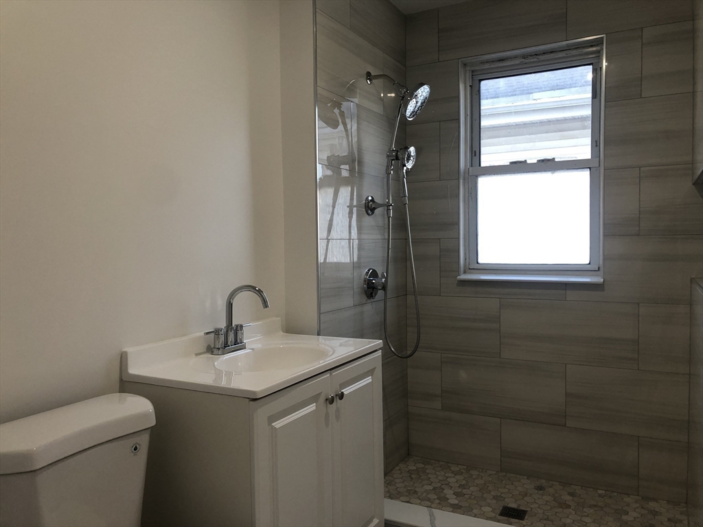 83-85 Neptune Street, Unit 2 Lynn, MA 01905 - Photo 7 of 8 a bathroom with a sink toilet and shower