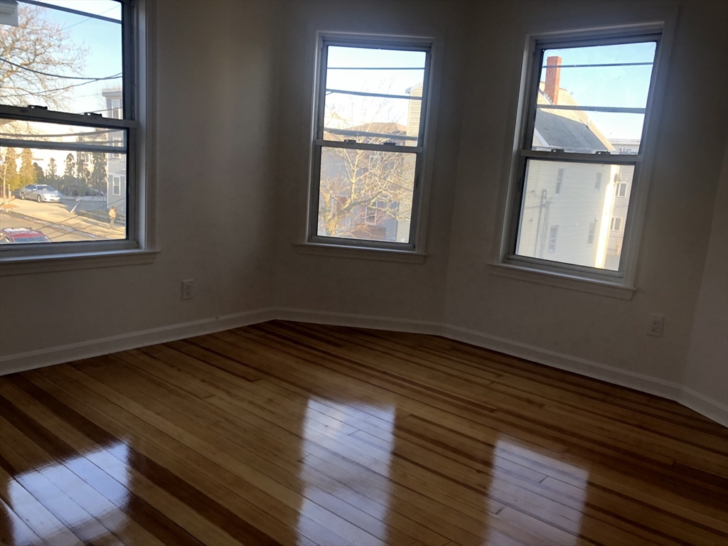 83-85 Neptune Street, Unit 2 Lynn, MA 01905 - Photo 8 of 8 a view of an empty room with wooden floor and a window