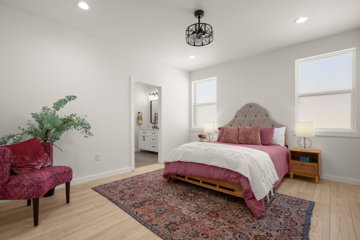 18208 Gregg Bluff Road Jonestown, TX 78645 - Photo 14 of 28 Bedroom with ensuite bathroom, light wood finished floors, and recessed lighting