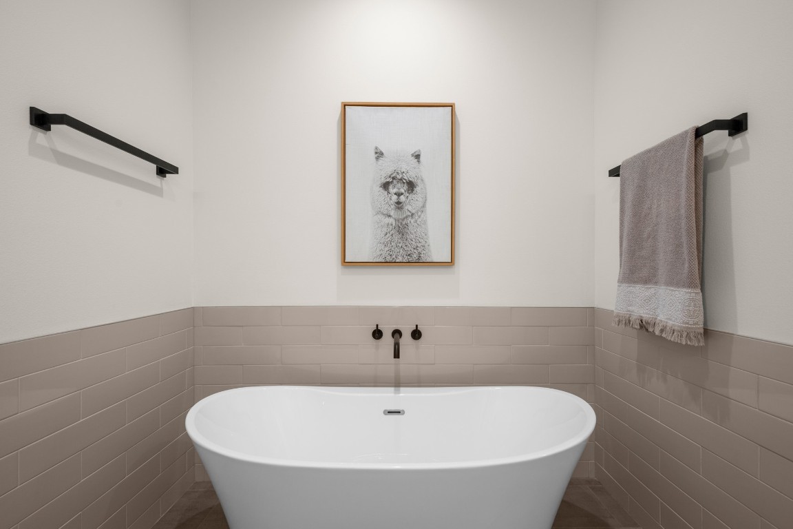 18208 Gregg Bluff Road Jonestown, TX 78645 - Photo 21 of 28 Bathroom with tile walls, wainscoting, and a soaking tub