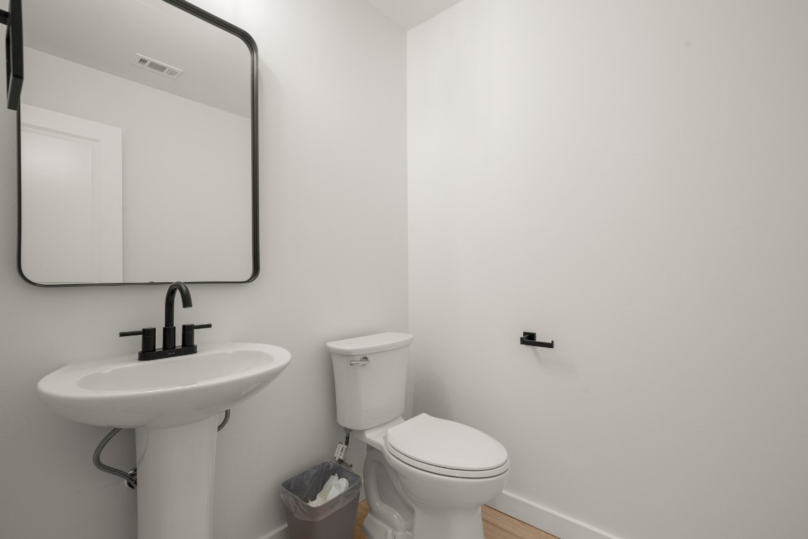 18208 Gregg Bluff Road Jonestown, TX 78645 - Photo 23 of 28 Half bath with baseboards and wood finished floors