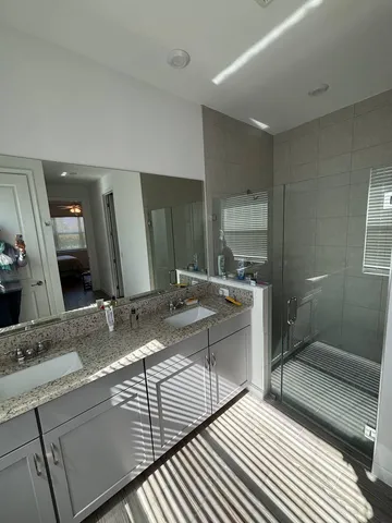 a bathroom with double vanity sink and a mirror