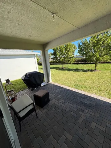 a view of a patio with lawn chairs under an umbrella