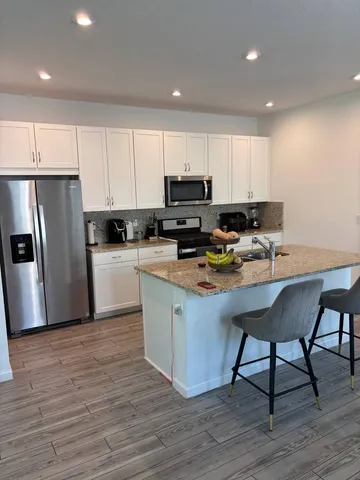 a kitchen with a sink cabinets and wooden floor