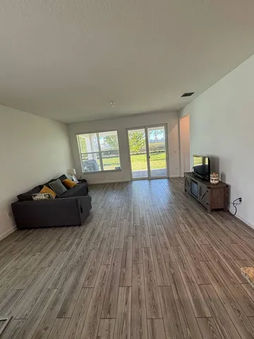 a living room with furniture and a wooden floor