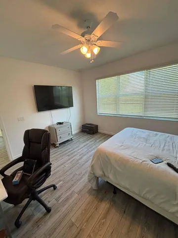 a bedroom with a bed and a flat screen tv