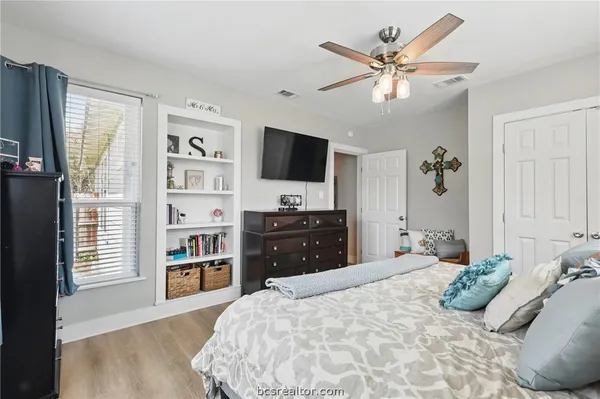 a bedroom with a bed and a large window