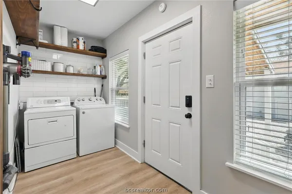 a kitchen with stainless steel appliances a table and chairs in it