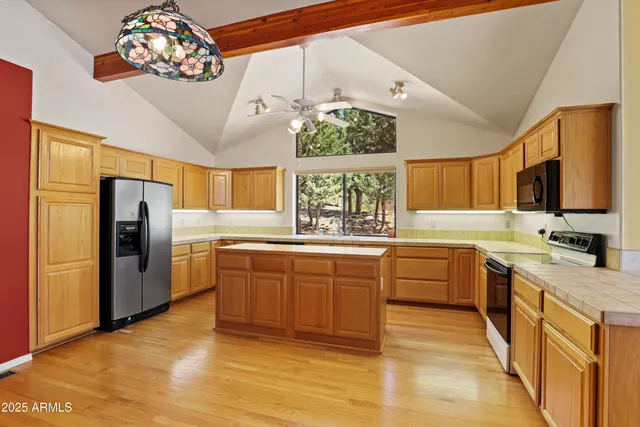 a kitchen with stainless steel appliances granite countertop a sink refrigerator stove and wooden cabinets