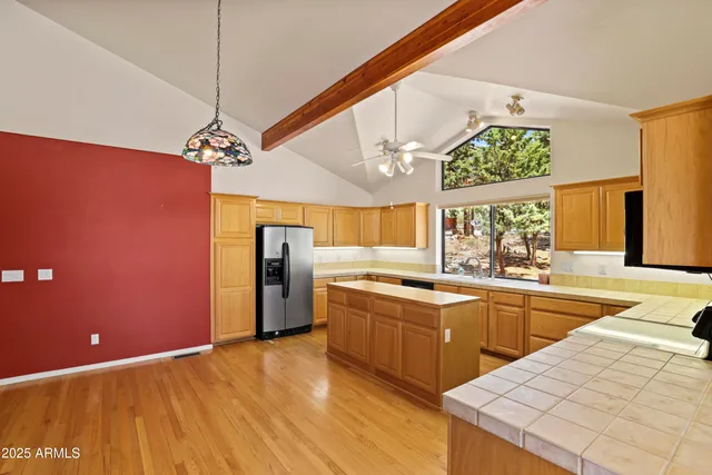 a view of a kitchen with a fridge and wooden floor