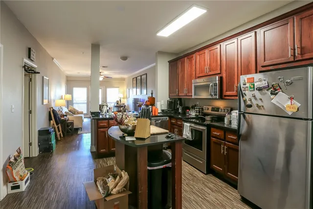 a kitchen with stainless steel appliances granite countertop a refrigerator stove microwave and sink