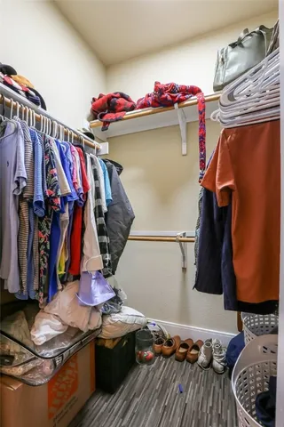a view of walk in closet with clothes and shoes